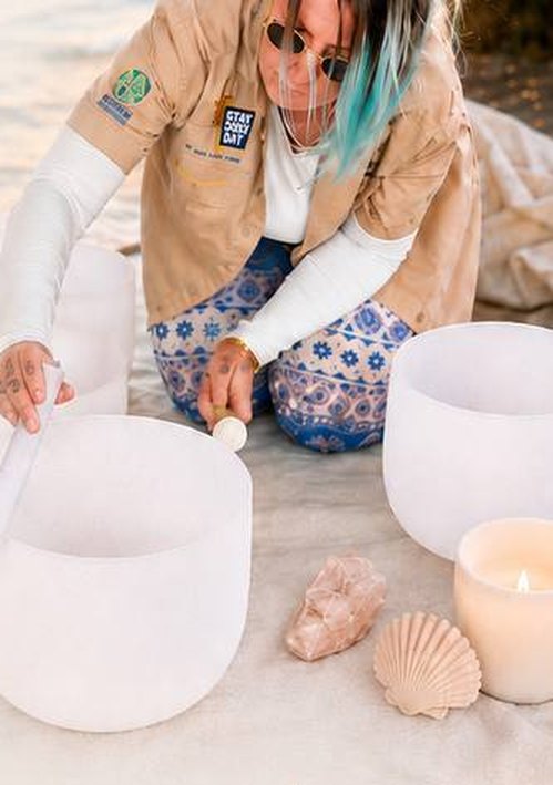 Viviana leading a Conscious Canine Awareness sound-healing session with crystal singing bowls on the beach